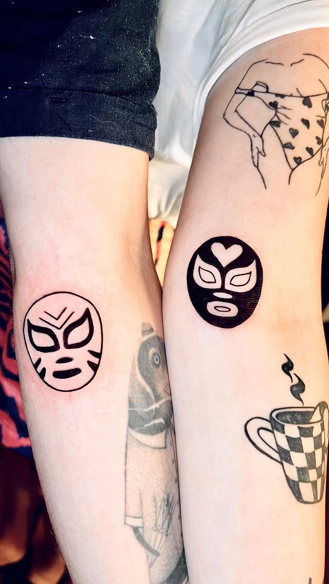 Matching luchador mask tattoos on two friends