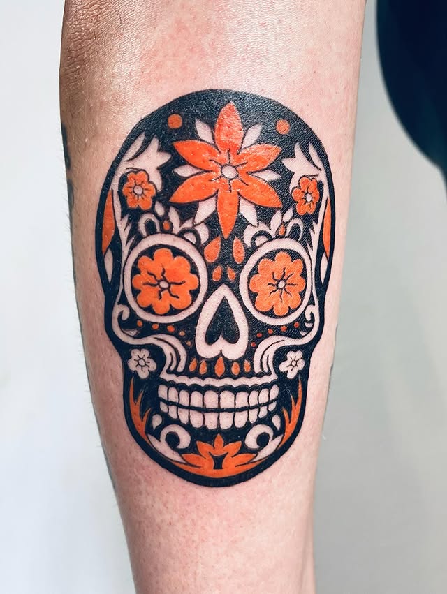 Dia de muertos sugar skull tattoo with orange flowers